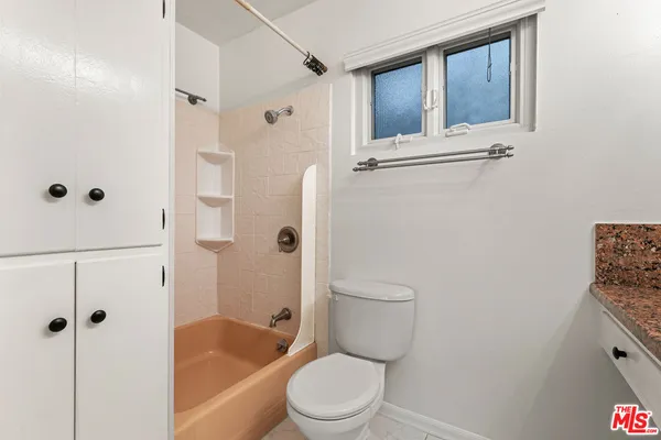 a white toilet sitting next to a bathroom sink