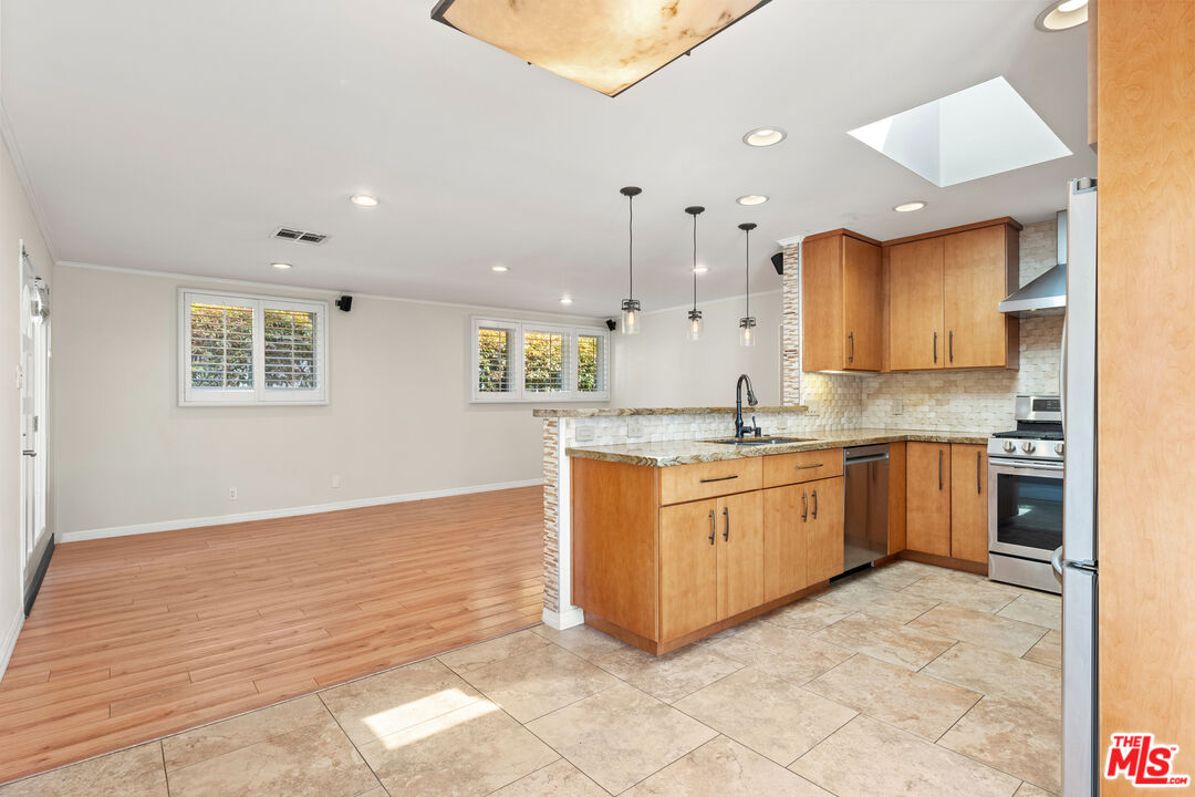 8255 Tuscany Avenue Playa del Rey, CA 90293 - Photo 21 of 24 a large kitchen with granite countertop a white stove top oven and cabinets