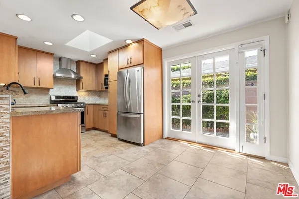 a kitchen with stainless steel appliances a refrigerator and a stove top oven