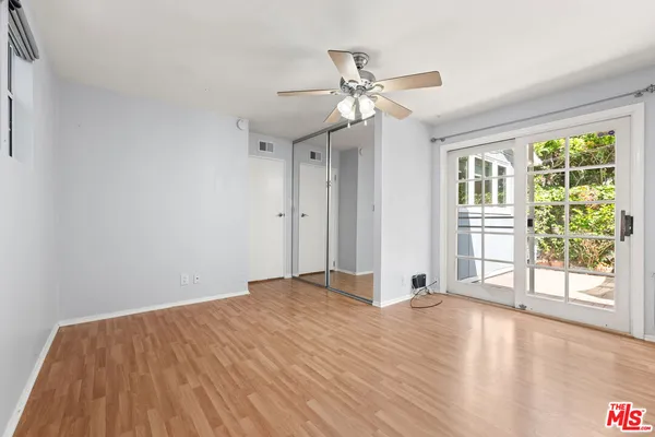 a view of a livingroom with wooden floor and a ceiling fan