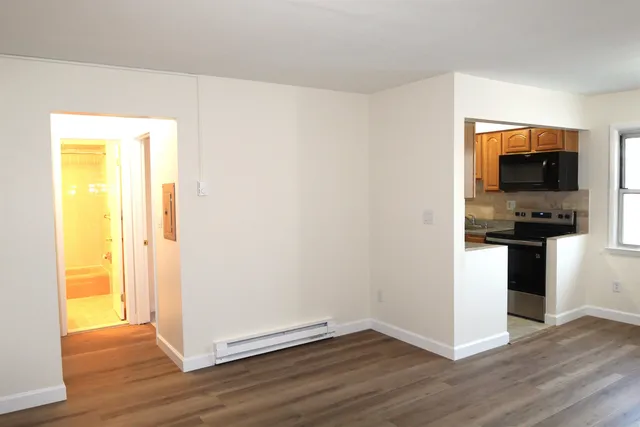 a view of kitchen with wooden floor and electronic appliances