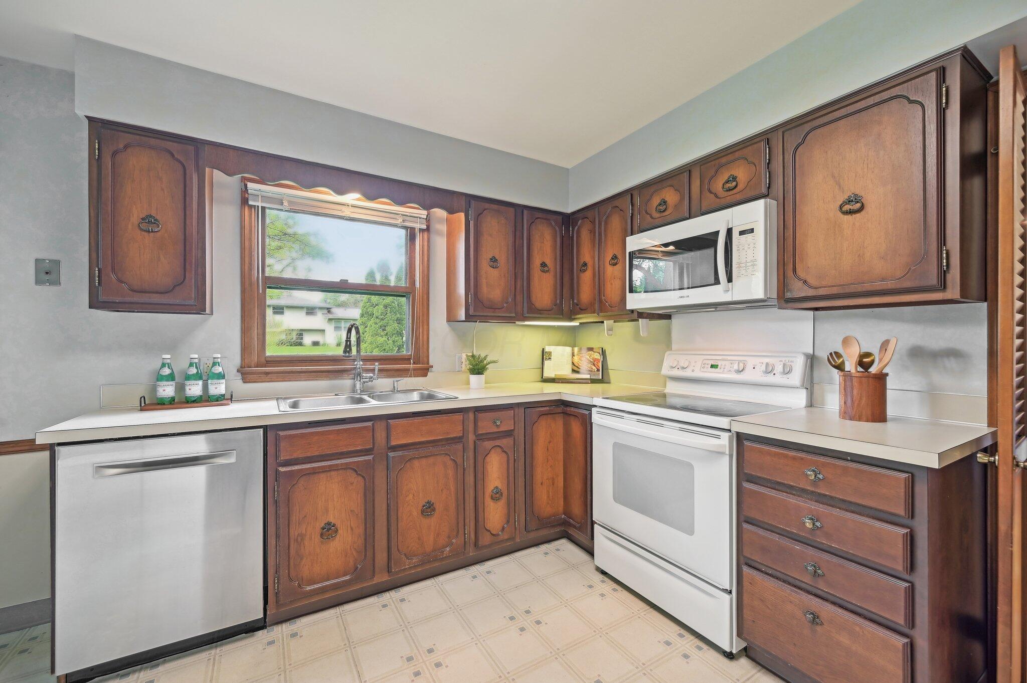 5917 Rocky Rill Road Columbus, OH 43235 - Photo 15 of 47 Kitchen – Closer View of Cabinets and Appliances
Detail shot of upper and lower cabinetry with built-in microwave and range. Tile flooring adds durability.