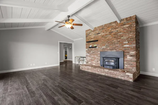 an empty room with wooden floor and ceiling fan