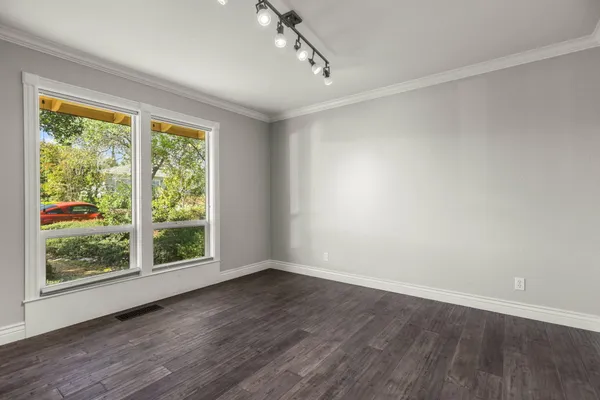 a view of a livingroom with wooden floor and furniture