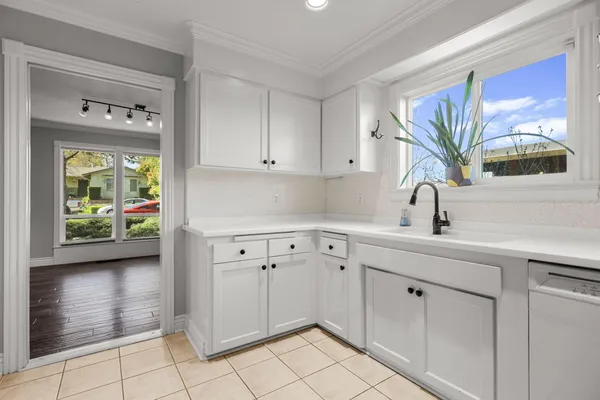 a kitchen with white cabinets and sink