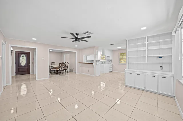 a view of a livingroom with furniture & a ceiling fan