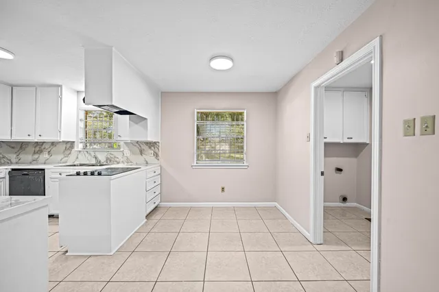 a kitchen with granite countertop white cabinets and white appliances
