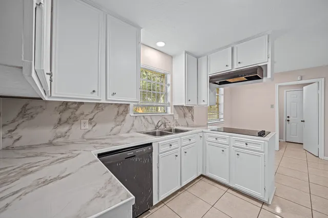 a kitchen with white cabinets stainless steel appliances and sink