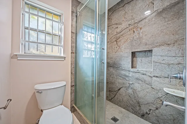 a bathroom with a toilet and a shower