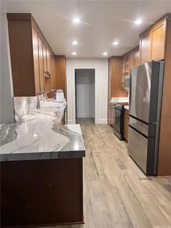 a kitchen with kitchen island a counter top space cabinets and stainless steel appliances