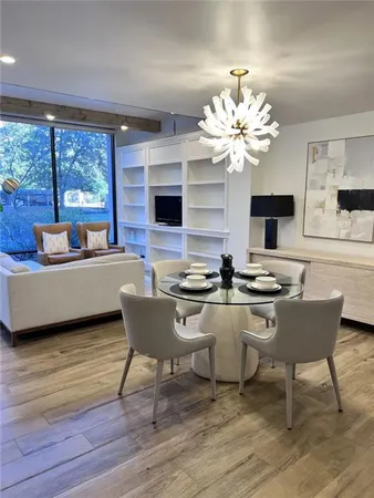 a view of a dining room with furniture a chandelier and wooden floor