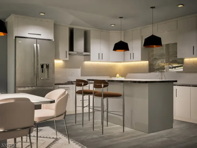 a kitchen with stainless steel appliances granite countertop a table chairs in it and wooden floors