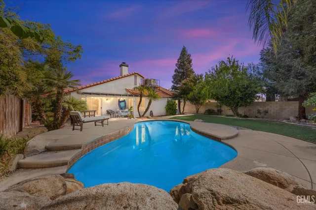 a view of a swimming pool with lounge chairs in patio