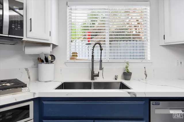 a kitchen with stainless steel appliances a stove microwave and sink