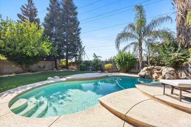 a front view of a house with a garden and a tree