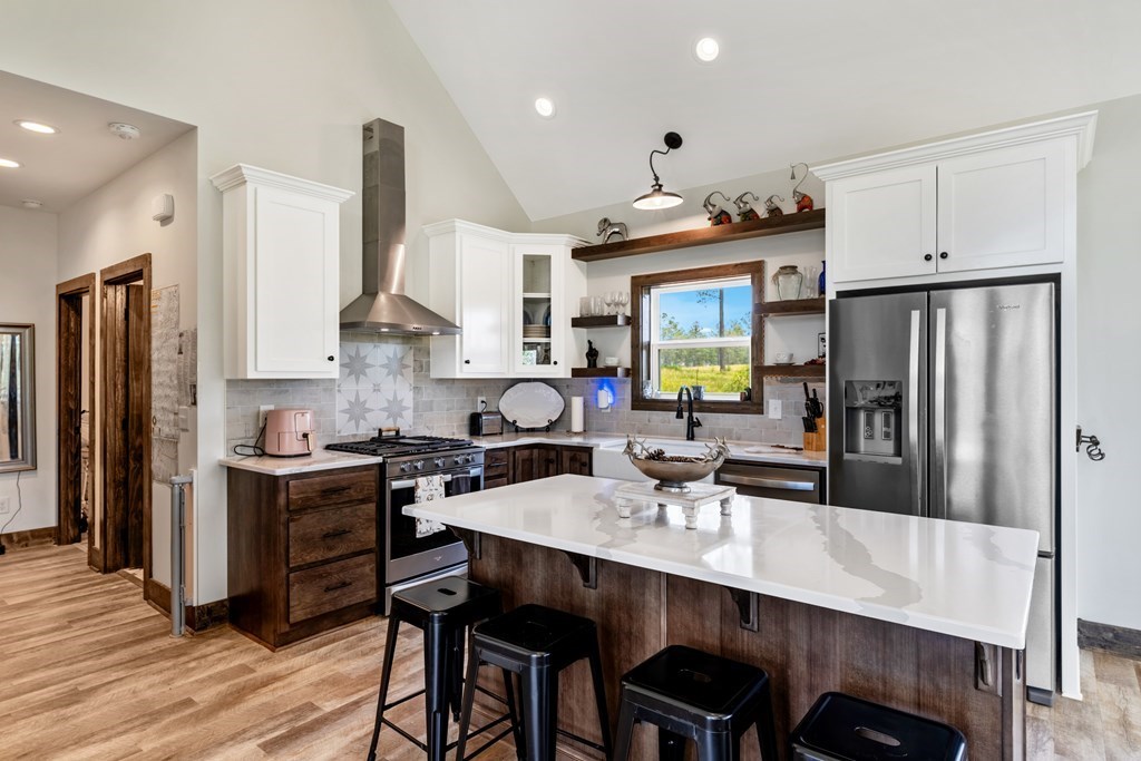 230 High River Road Ellijay, GA 30540 - Photo 7 of 27 a kitchen with stainless steel appliances granite countertop a stove refrigerator a sink dishwasher and white cabinets with wooden floor