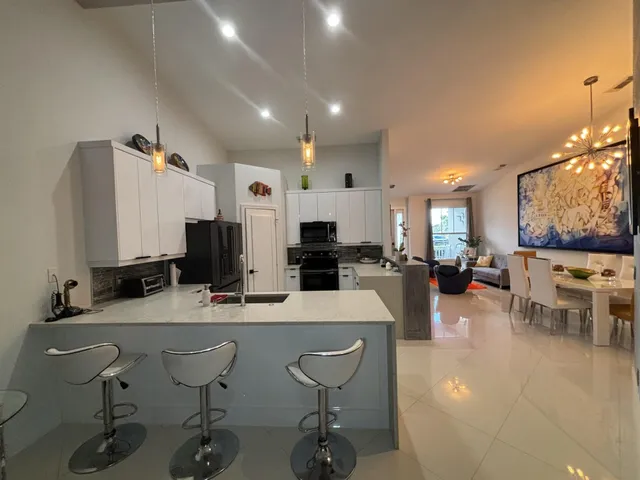 a kitchen with sink a refrigerator and chairs