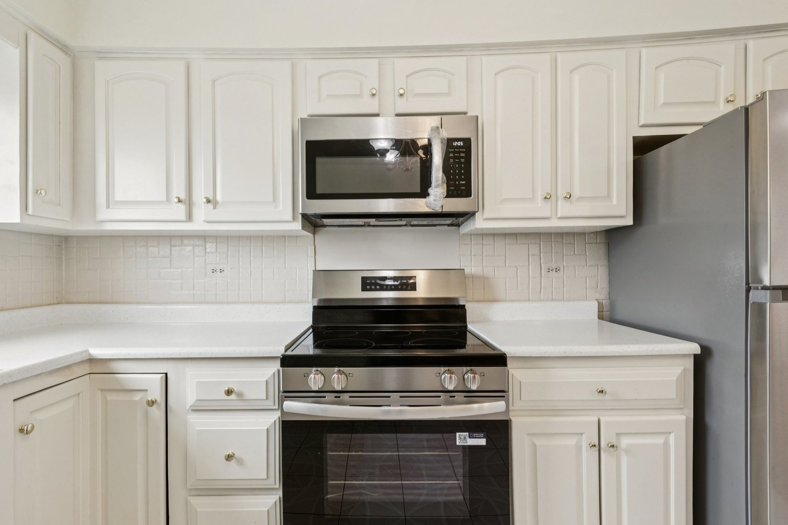 702 Cobblestone Circle, Unit D Glenview, IL 60025 - Photo 10 of 25 a kitchen with stainless steel appliances granite countertop white cabinets a stove a microwave and a refrigerator
