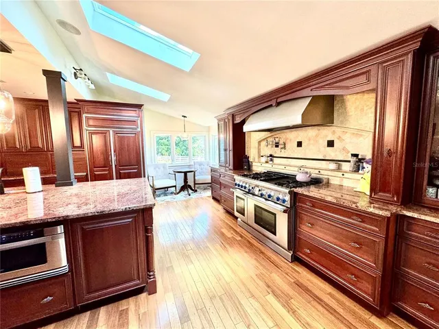a kitchen with stainless steel appliances granite countertop a stove a sink and a microwave