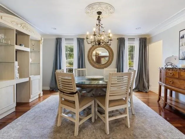 a dining room with furniture a chandelier and wooden floor