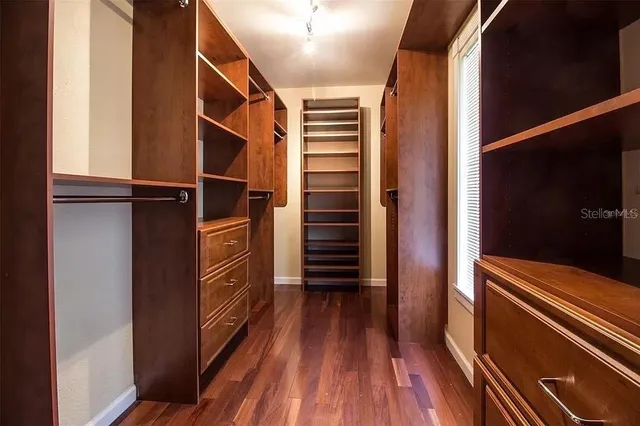a view of walk in closet with wooden floor