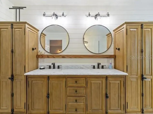 a bathroom with a granite countertop double vanity sink and a mirror