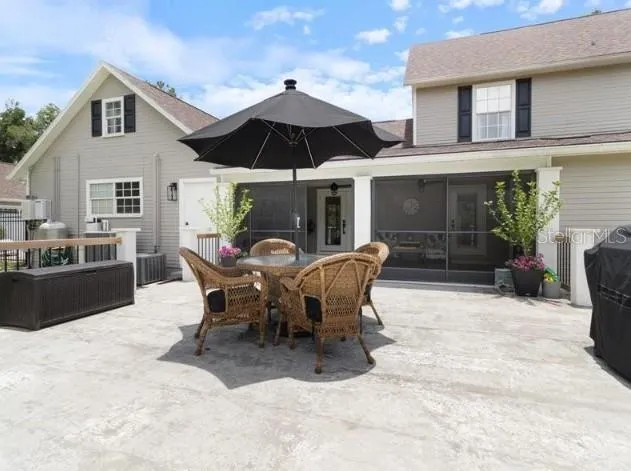 a view of a patio with a dining table and chairs under an umbrella