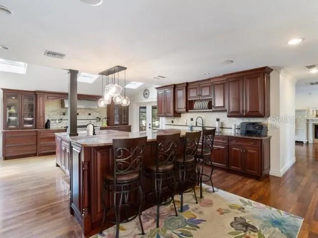 a kitchen with stainless steel appliances granite countertop wooden cabinets a dining table and chairs