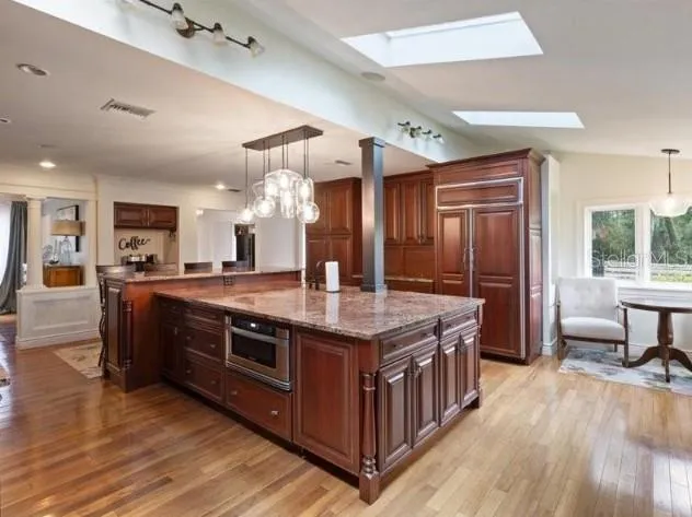 a kitchen with stainless steel appliances granite countertop a stove and a wooden floors
