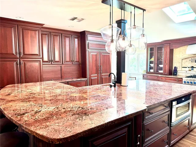 a kitchen with kitchen island granite countertop wooden cabinets and a granite counter tops