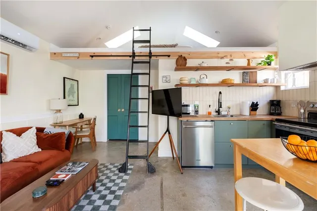 a living room with stainless steel appliances kitchen island granite countertop furniture and a view of kitchen