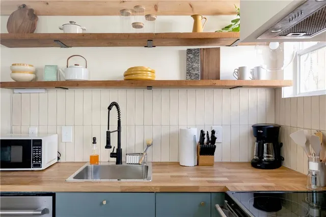 a kitchen with a sink and a stove with wooden floor
