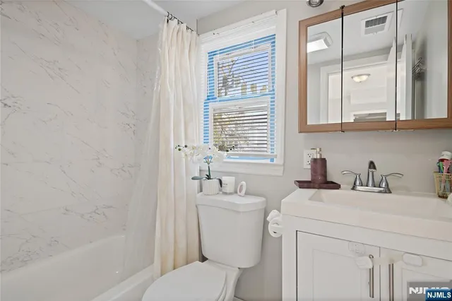 a bathroom with a sink toilet vanity and tub