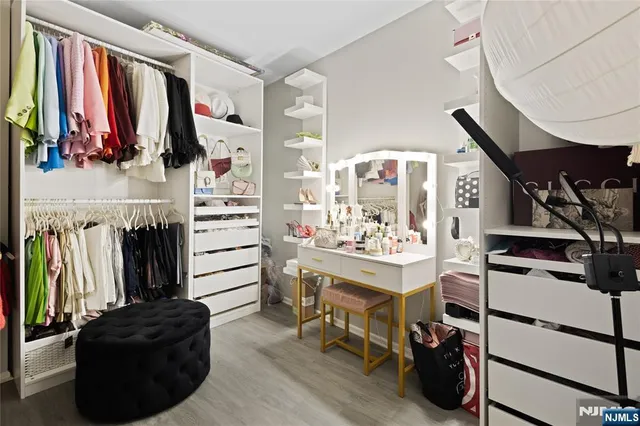 a view of walk in closet with clothes and shoes