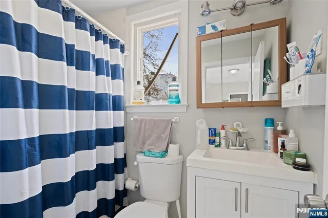 a bathroom with a sink a toilet and a shower curtain