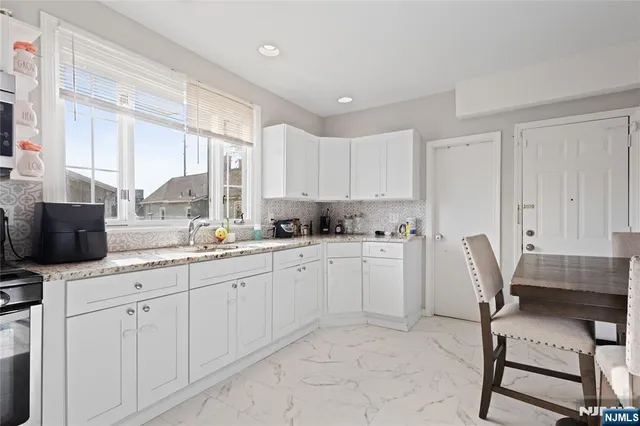 a kitchen with white cabinets and chair