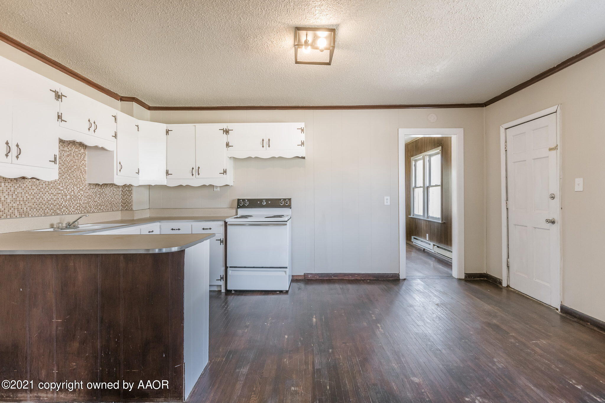 1104 South Western Street Amarillo, TX 79106 - Photo 9 of 29 a kitchen with wooden floors and white appliances