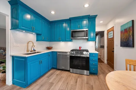 a kitchen with stainless steel appliances granite countertop wooden cabinets a stove top oven a sink and dishwasher