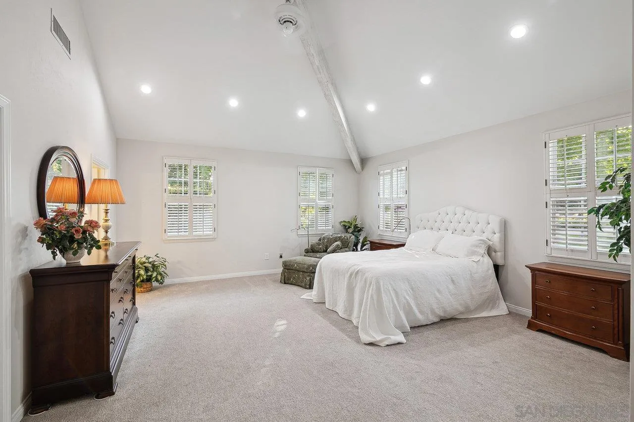 1532 Rancho Encinitas Drive Encinitas, CA 92024 - Photo 31 of 74 a spacious bedroom with a bed and a chandelier