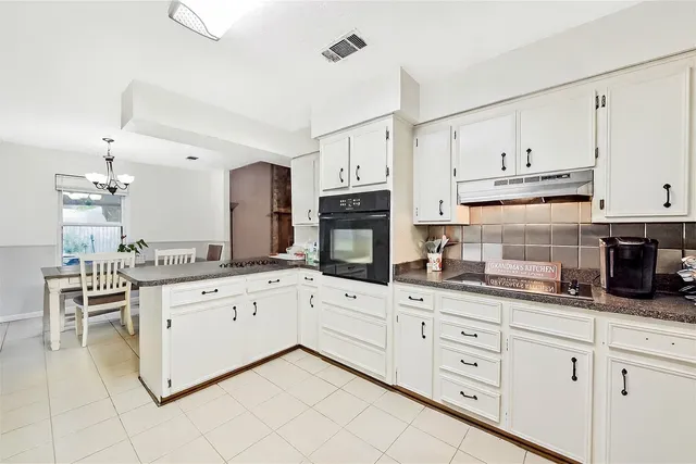 a kitchen with granite countertop white cabinets white stainless steel appliances with a sink and dishwasher