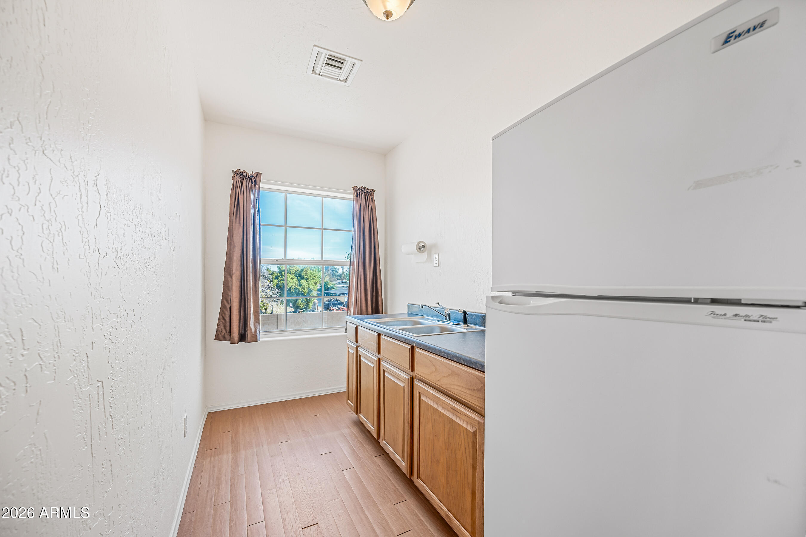 322 East Redfield Road Chandler, AZ 85225 - Photo 39 of 50 a kitchen with granite countertop a refrigerator a sink and dishwasher with wooden floor