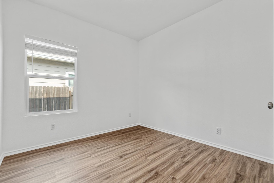 348 Soapstone Pass Maxwell, TX 78656 - Photo 16 of 18 an empty room with wooden floor and windows