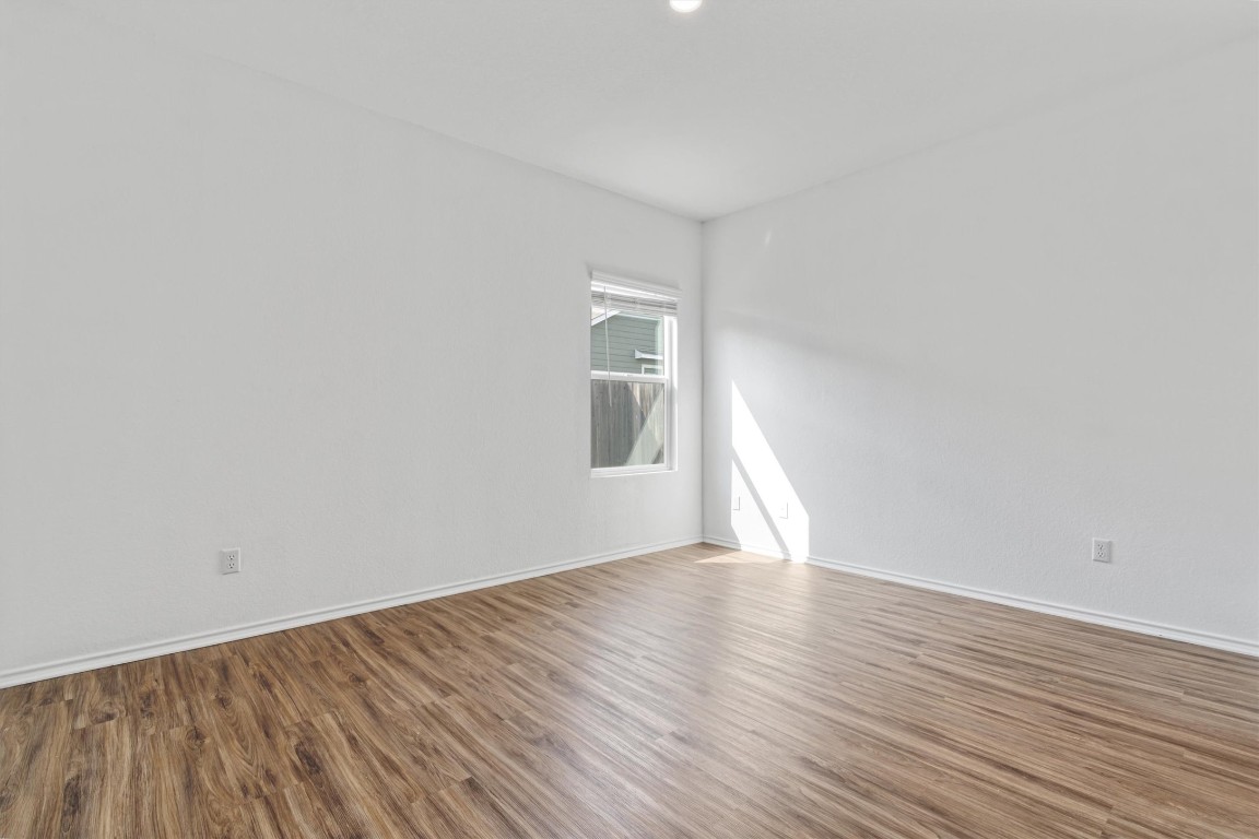 348 Soapstone Pass Maxwell, TX 78656 - Photo 9 of 18 a view of an empty room with wooden floor and a window