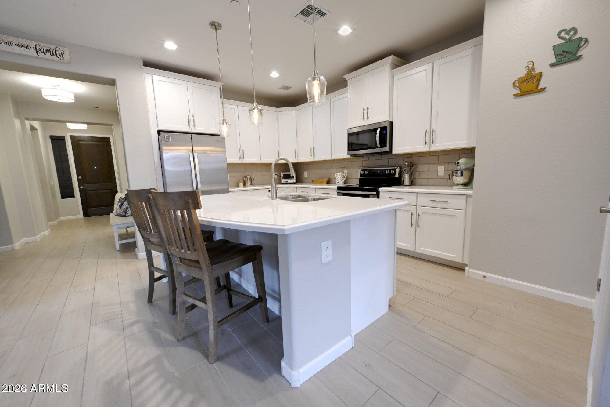 576 Whistle Stop Road Clarkdale, AZ 86324 - Photo 11 of 50 a kitchen with stainless steel appliances granite countertop a stove a sink a microwave a refrigerator and white cabinets with wooden floor