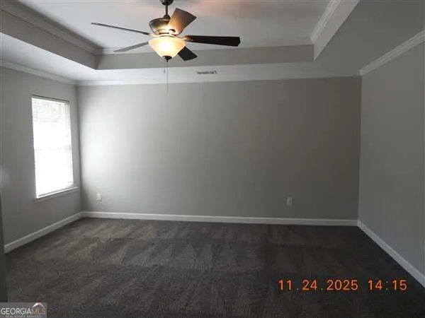 an empty room with a window and a ceiling fan