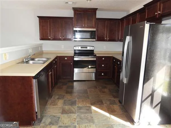 a kitchen with a refrigerator and a sink