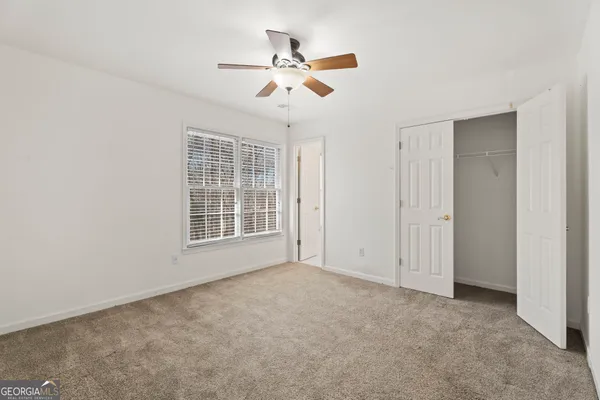 a view of an empty room with a ceiling fan and a window