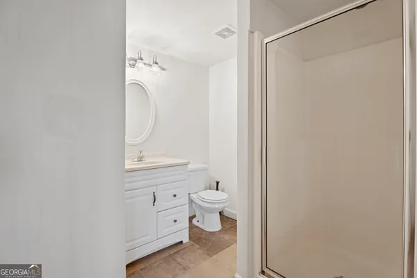 a bathroom with a granite countertop sink a toilet and a mirror