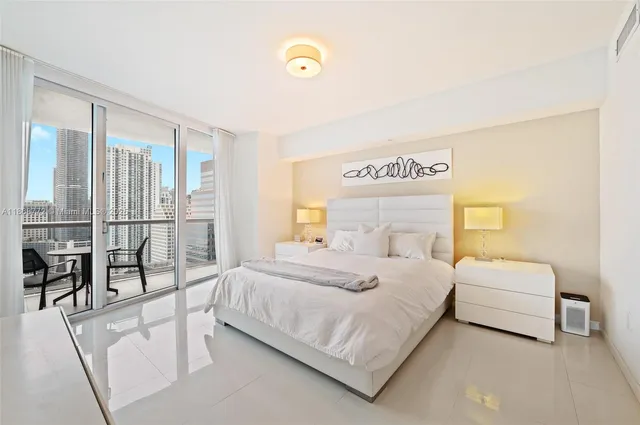 a bedroom with a bed and a large window