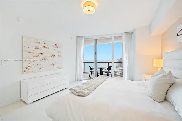 a bedroom with a bed and painting on the wall